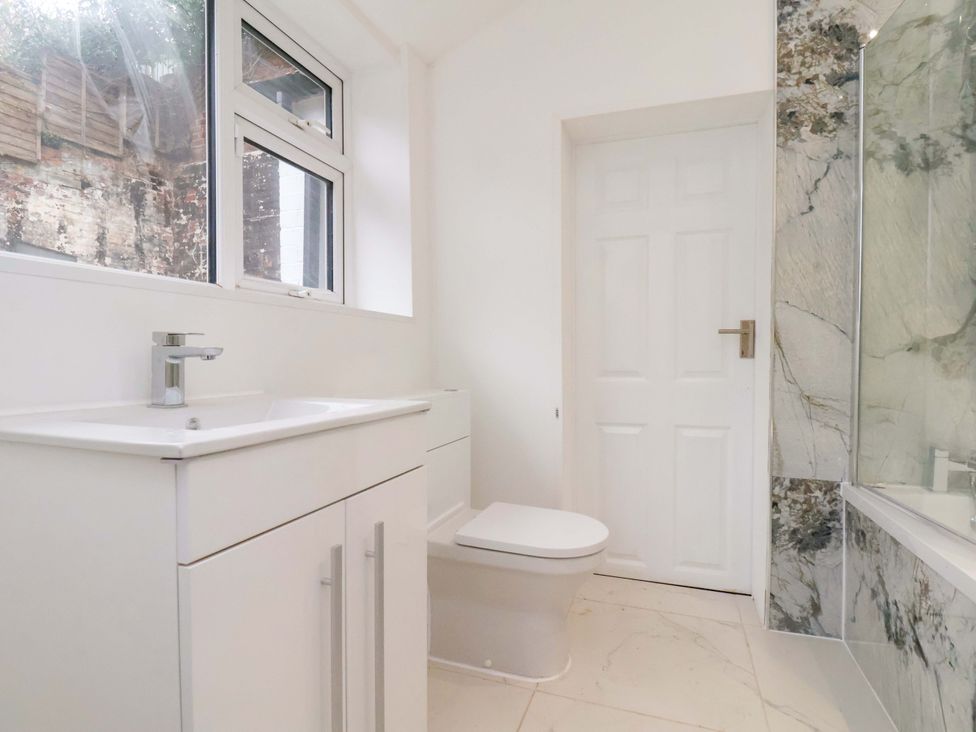 A bathroom with a sink and toilet at Beachwalk Villa 1
