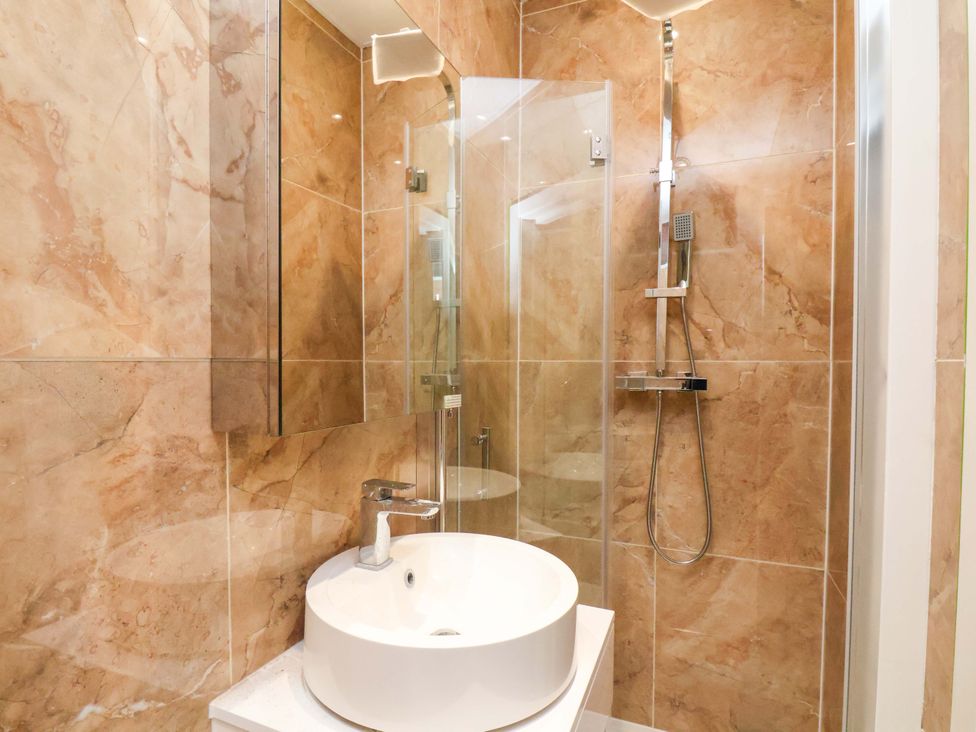 A bathroom featuring a sink, shower, and mirror at Beachwalk Villa 1