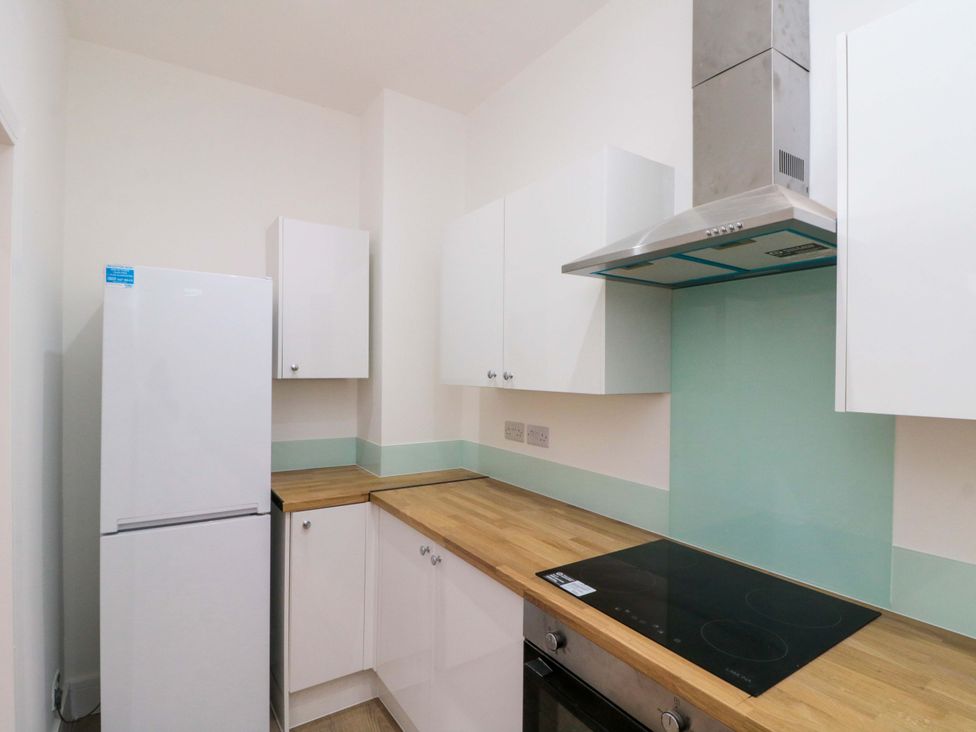 A kitchen with a refrigerator and cabinets at Beachwalk Villa 1