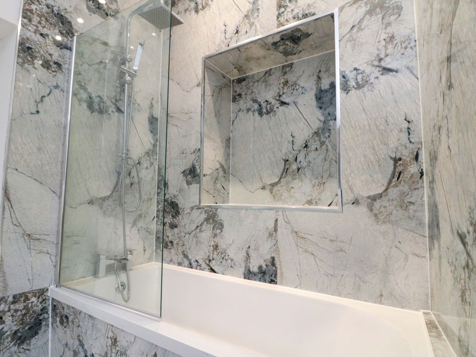 A bathroom with a shower and bathtub at Beachwalk Villa 1