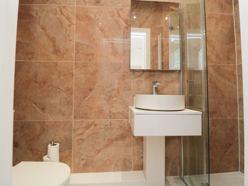 A bathroom with a sink, toilet, and shower at Beachwalk Villa 1, Whitby