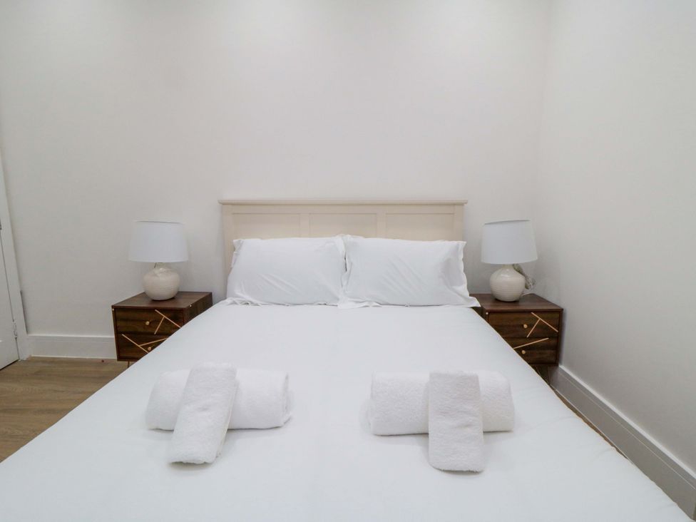 A bed with pillows and towels in the bedroom at Beachwalk Villa 1 Whitby