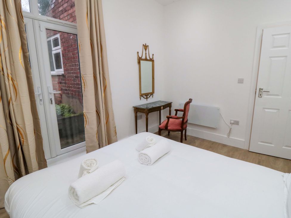 A bedroom with a bed and a mirror at Beachwalk Villa 1 in Whitby