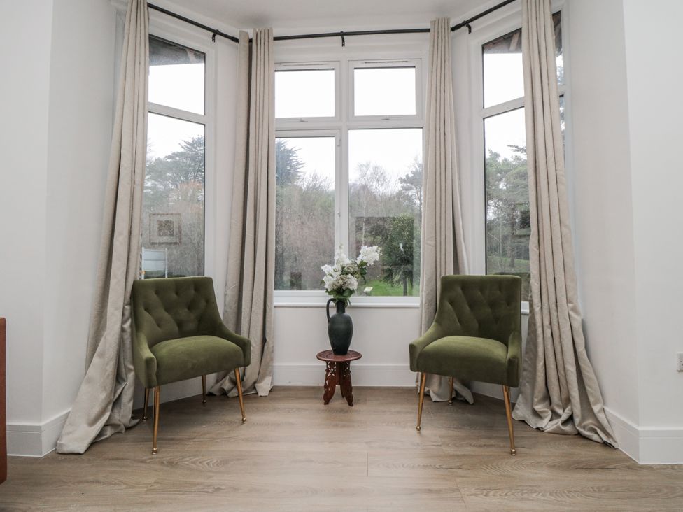 A living room with chairs and a flower arrangement at Beachwalk Villa 1 in Whitby