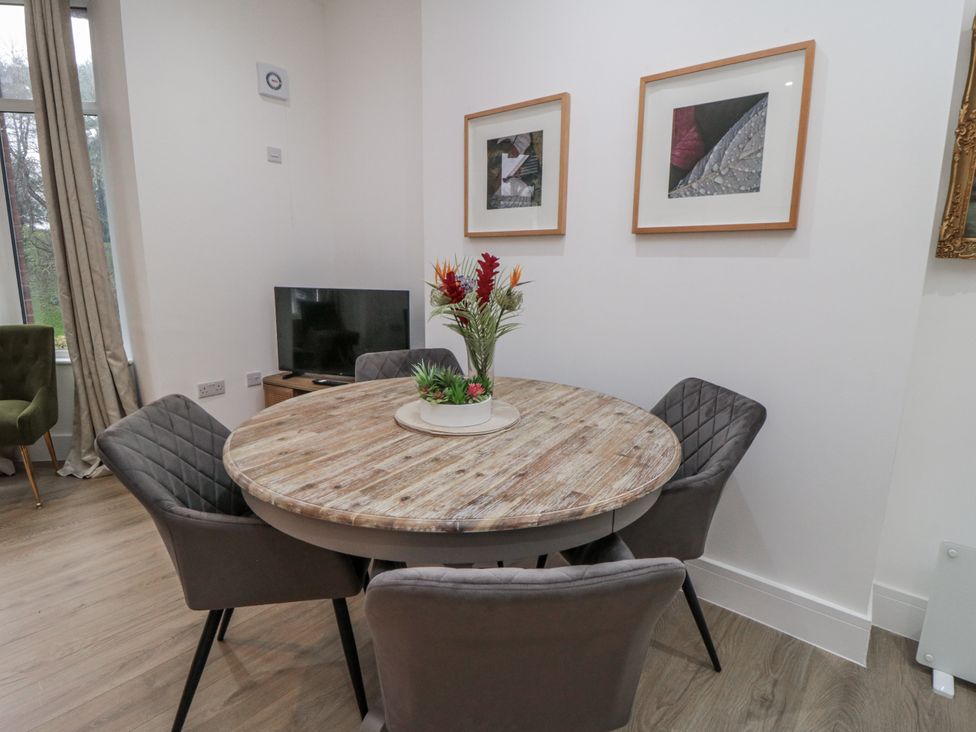 A dining room with a round table and four chairs at Beachwalk Villa 1 in Whitby