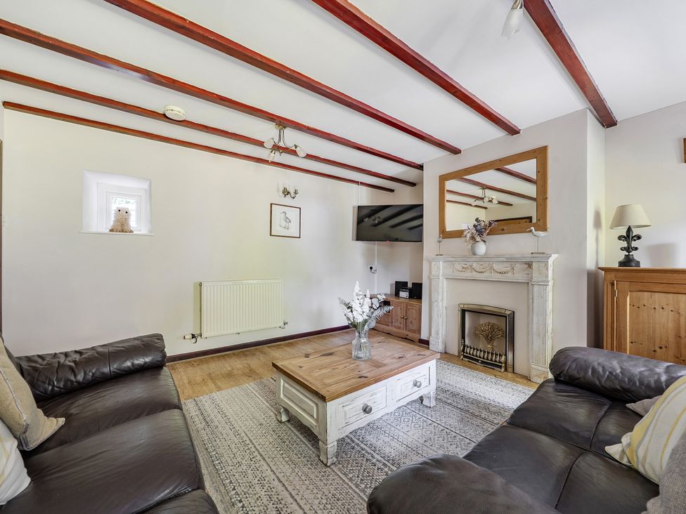 A living room with a sofa and coffee table at Tyn Y Ffynnon in Betws-Y-Coed