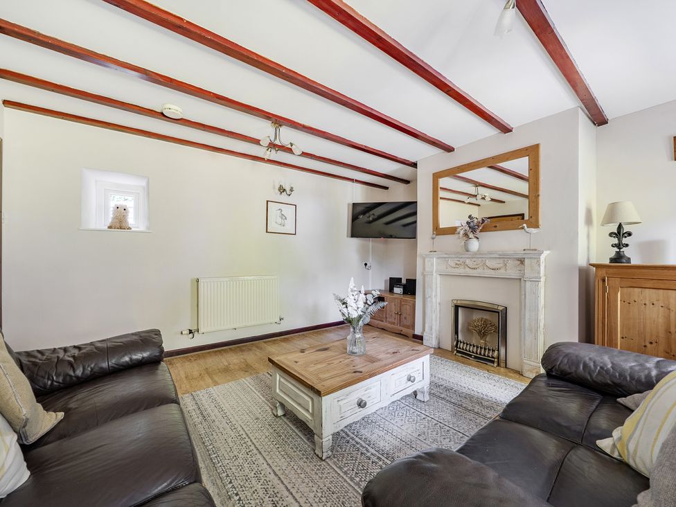 A living room with a sofa and coffee table at Tyn Y Ffynnon in Betws-Y-Coed