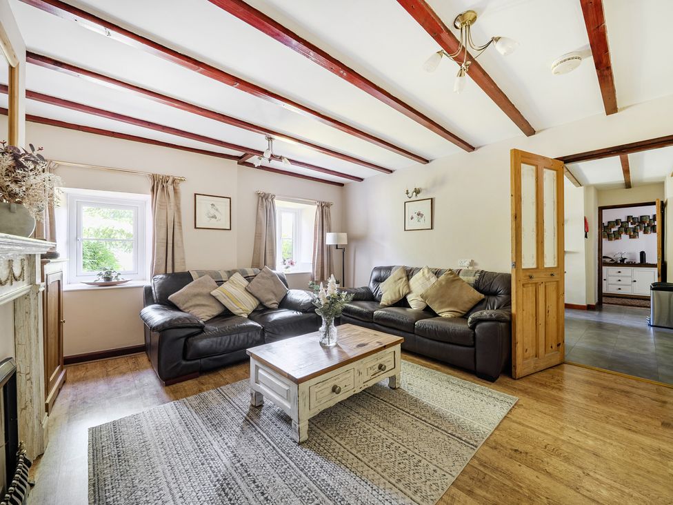 A living room with a sofa and coffee table at Tyn Y Ffynnon in Betws-Y-Coed