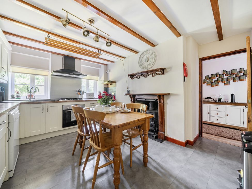 A kitchen with a dining table and chairs at Tyn Y Ffynnon in Betws-Y-Coed