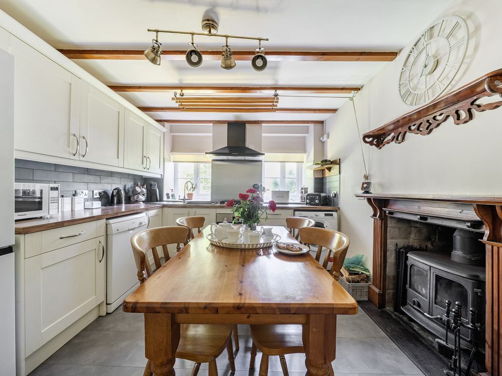 A kitchen with a table and chairs at Tyn Y Ffynnon in Betws-Y-Coed