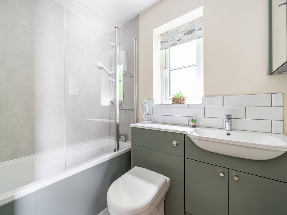 A bathroom with a bathtub, toilet, and sink at Tyn Y Ffynnon in Betws-Y-Coed