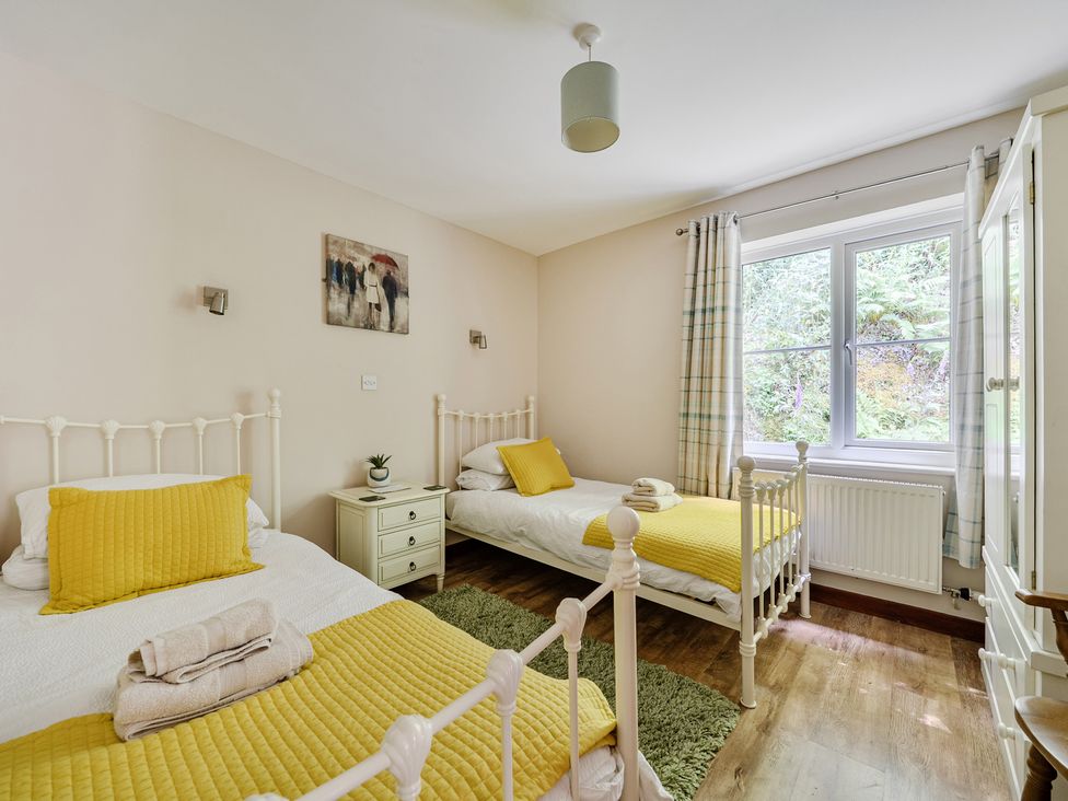 A bedroom with two beds and a nightstand at Tyn Y Ffynnon in Betws-Y-Coed