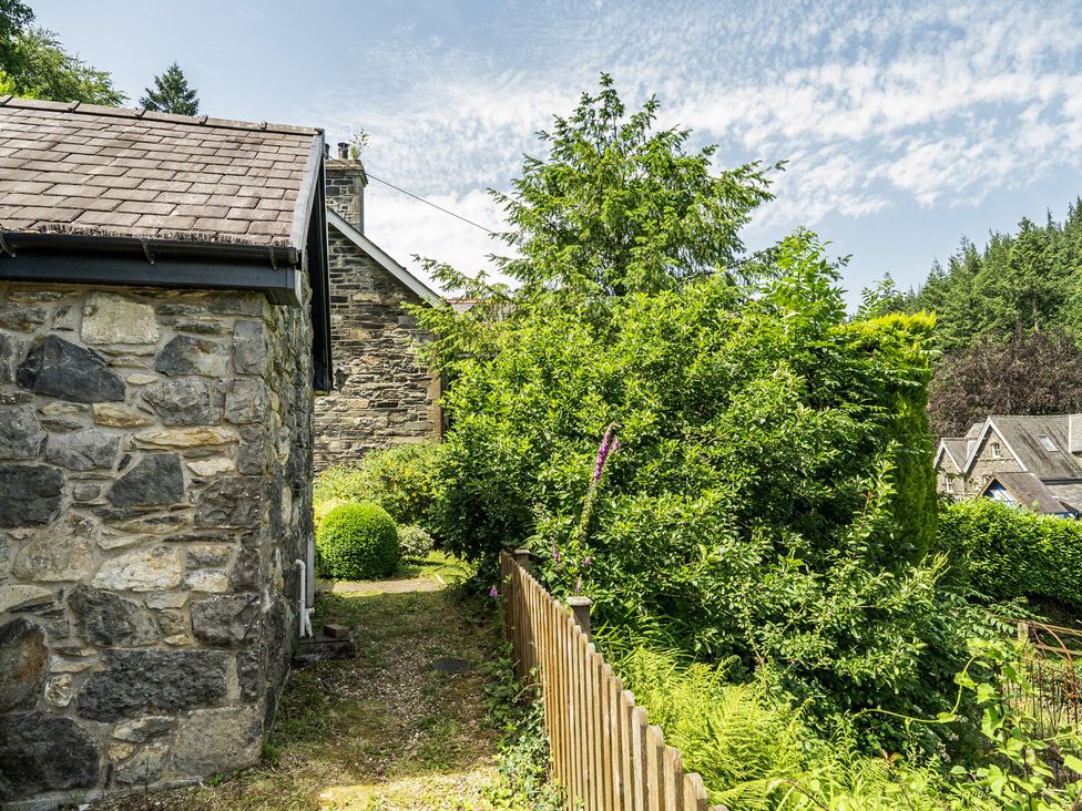 A garden with stone walls and greenery at Tyn Y Ffynnon in Betws-Y-Coed