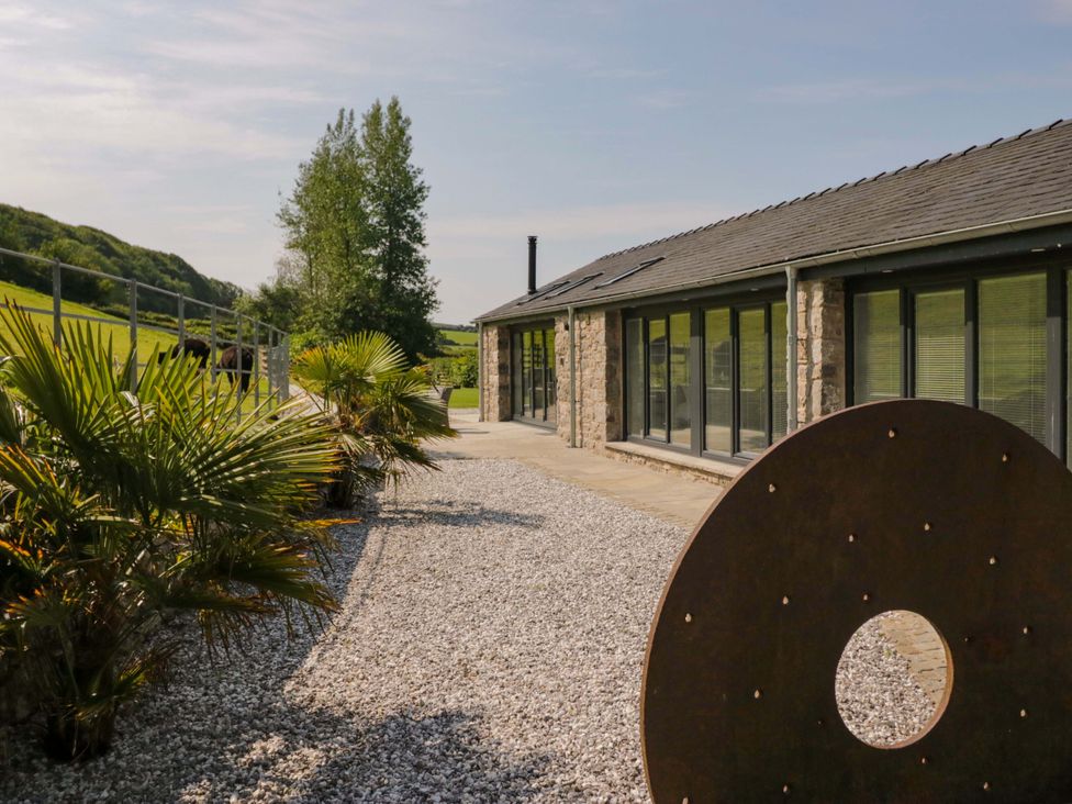 An outdoor area with a building, plants, and gravel at Limestone in Great Urswick