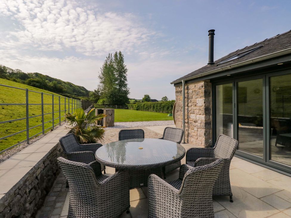 An outdoor patio with a table and chairs at Limestone in Great Urswick