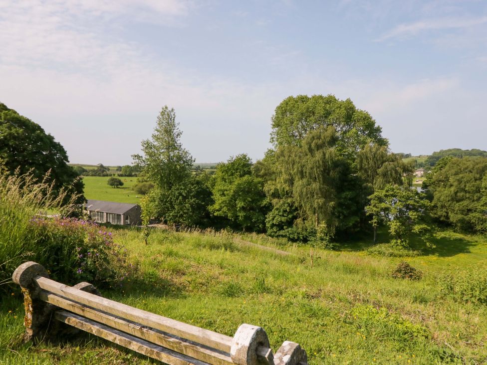 A view of a landscape with trees and a building at Limestone in Great Urswick