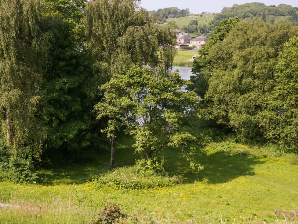 A landscape with trees and water near houses at Limestone in Great Urswick