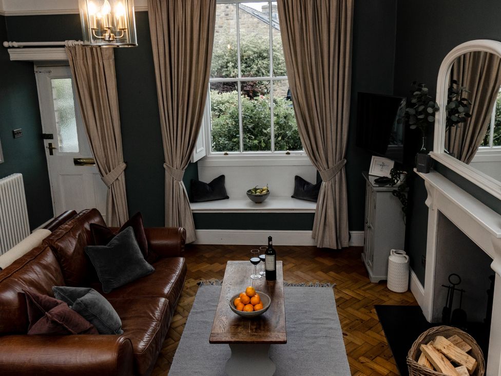 A living room with a sofa and a coffee table with fruit at Pendle View Luxury Apartment in Giggleswick near Settle