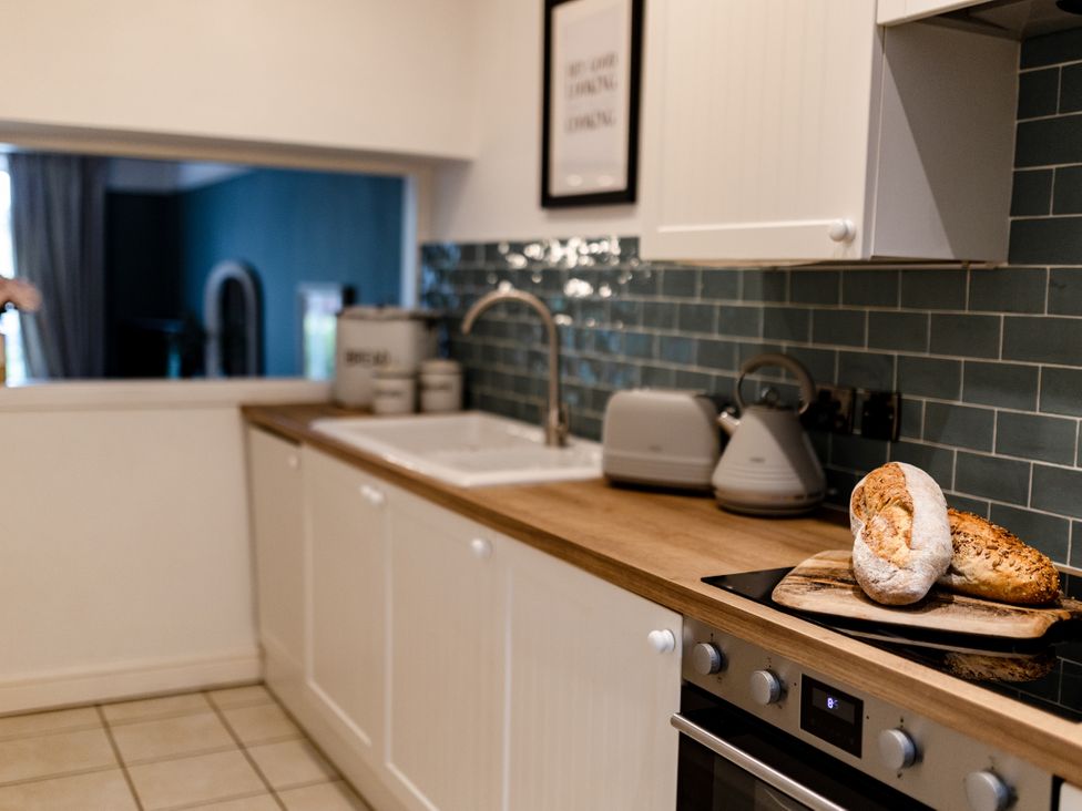 A kitchen with a sink and bread on a cutting board at Pendle View Luxury Apartment in Giggleswick near Settle