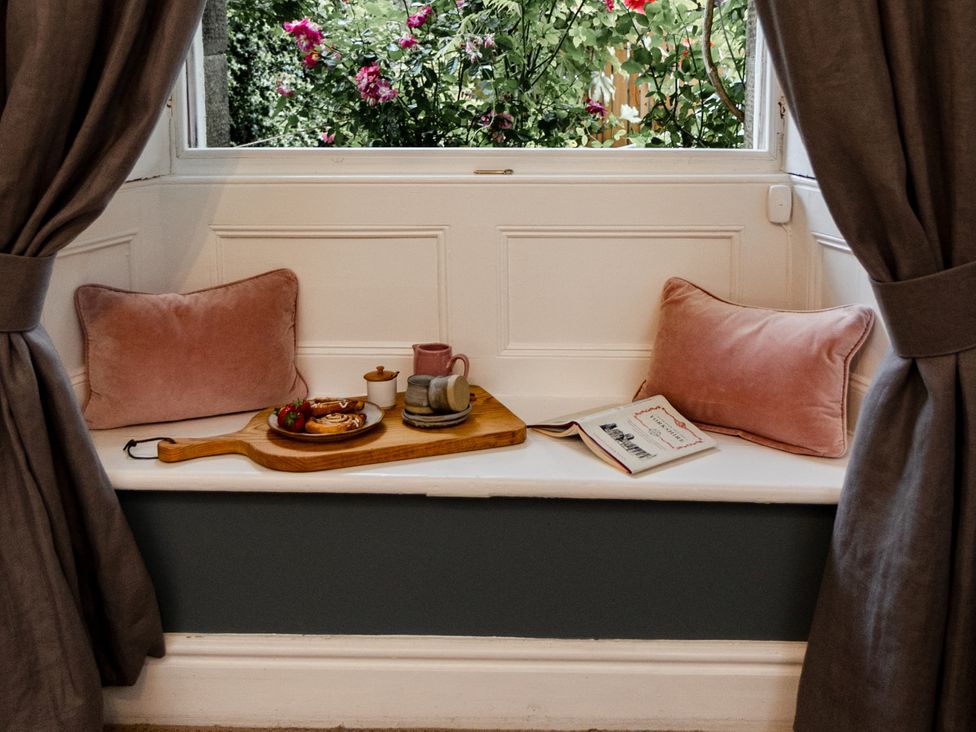 A window seat with a tray of food and a book at Pendle View Luxury Apartment, Giggleswick near Settle