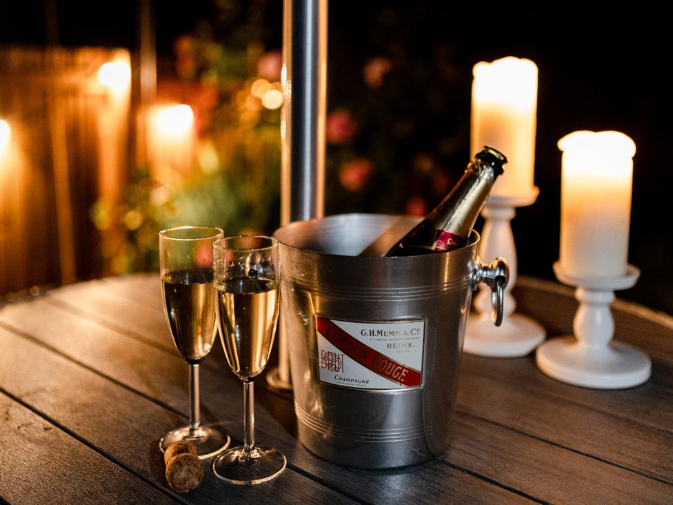 Champagne and glasses on a table with candles at Pendle View Luxury Apartment in Giggleswick near Settle