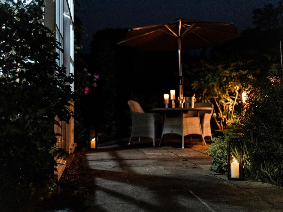 A patio with a table and chairs, with candles and lights at Pendle View Luxury Apartment in Giggleswick near Settle