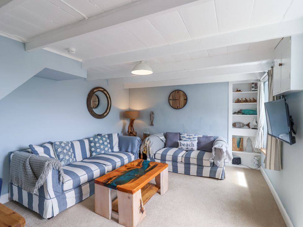 A living room with a sofa, coffee table, and television at 2 Cliff Cottages West Portholland near Gorran Haven