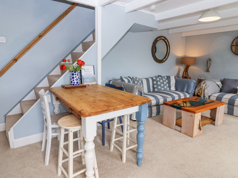 A living room with a table and chairs at 2 Cliff Cottages in West Portholland near Gorran Haven