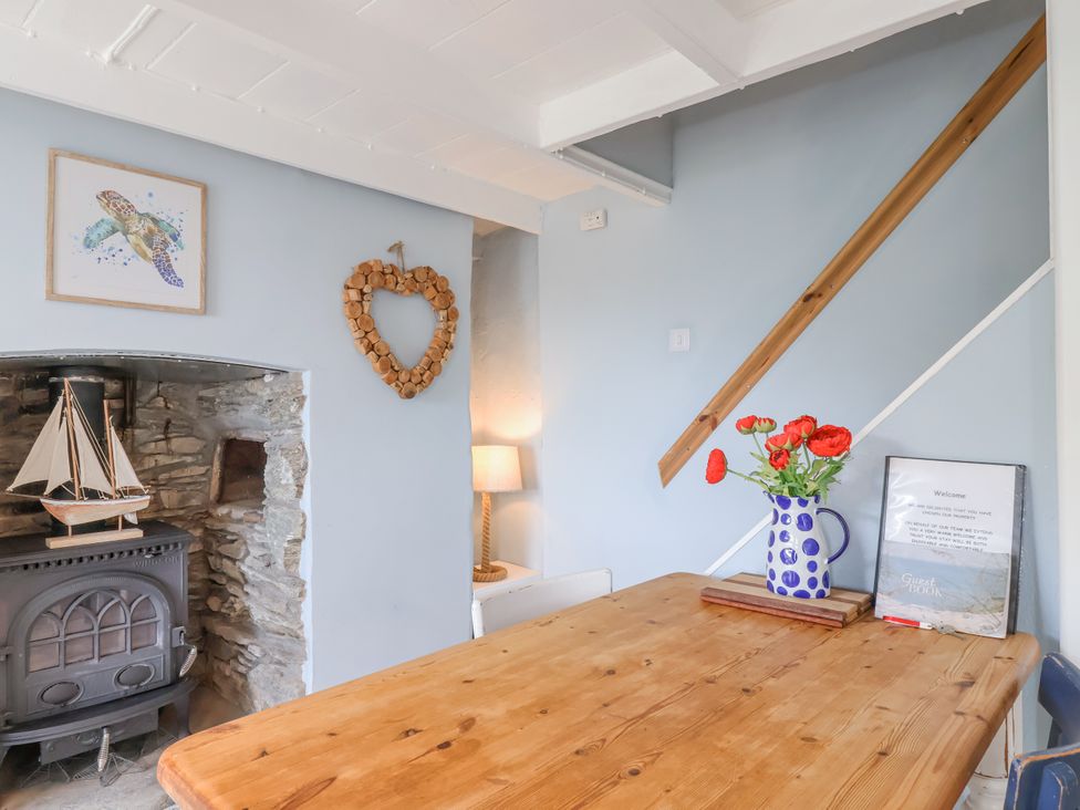 A dining room with a table and chair at 2 Cliff Cottages West Portholland near Gorran Haven