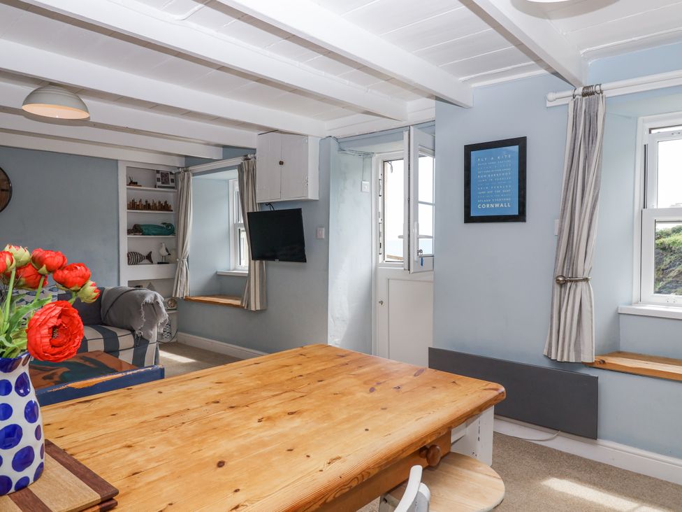 A dining room with a wooden table and chairs at 2 Cliff Cottages West Portholland near Gorran Haven