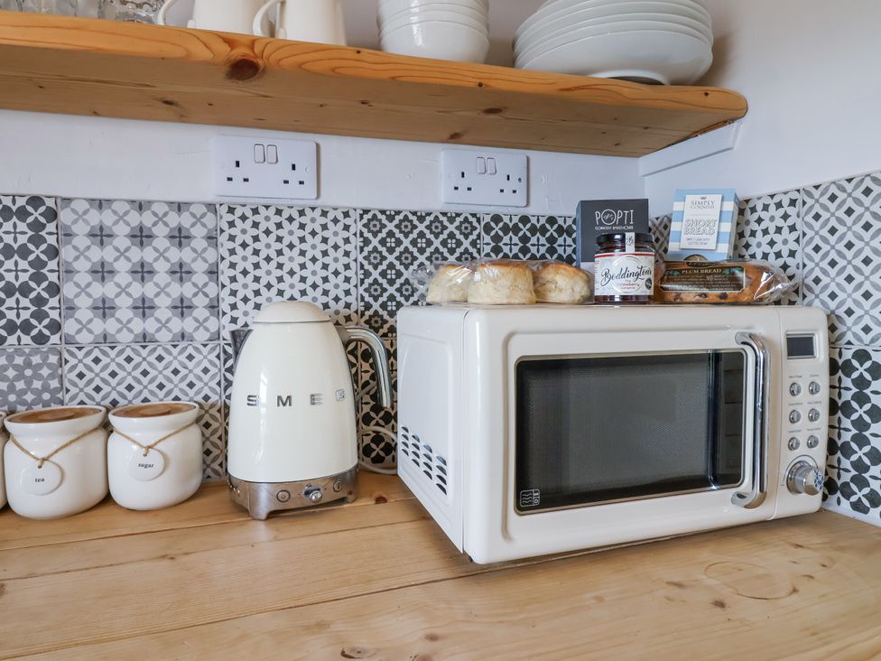 A kitchen with a microwave and kettle at 2 Cliff Cottages West Portholland near Gorran Haven