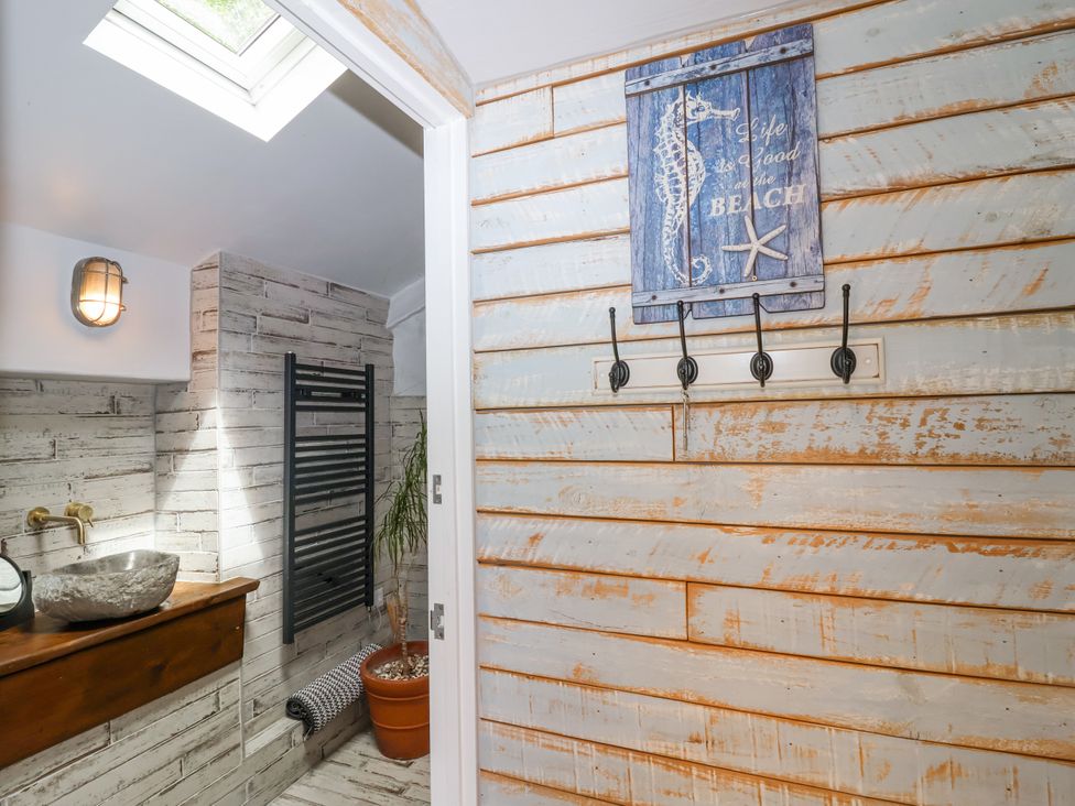 A bathroom with a sink and towel rack at 2 Cliff Cottages West Portholland near Gorran Haven