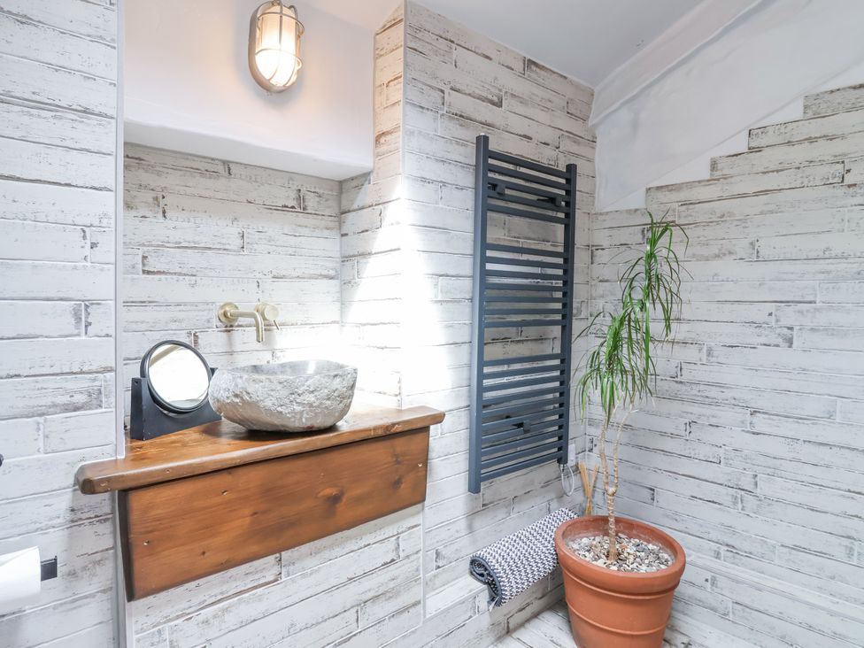 A bathroom with a stone sink and towel rack at 2 Cliff Cottages in West Portholland near Gorran Haven