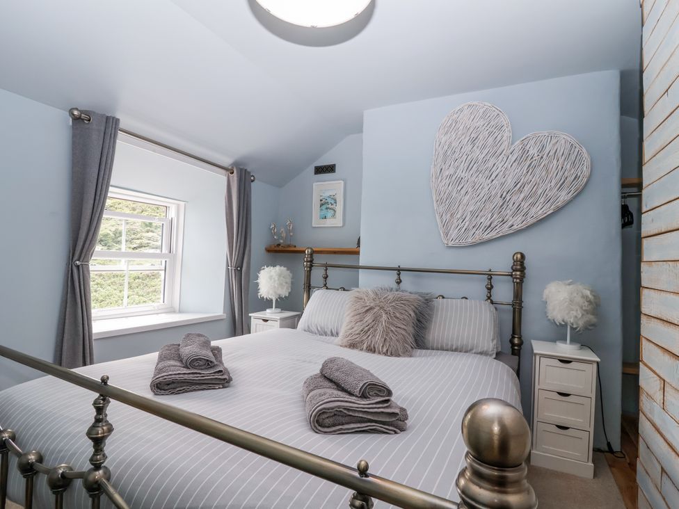 A bedroom with a bed and window at 2 Cliff Cottages in West Portholland near Gorran Haven