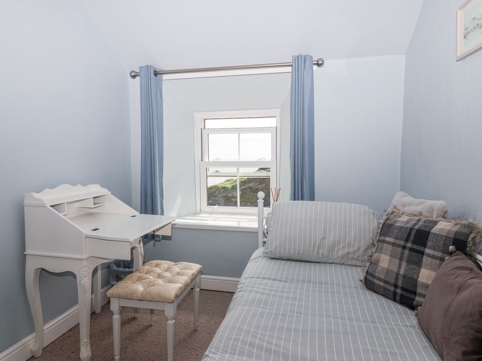 A bedroom with a desk, chair, and a window at 2 Cliff Cottages West Portholland near Gorran Haven