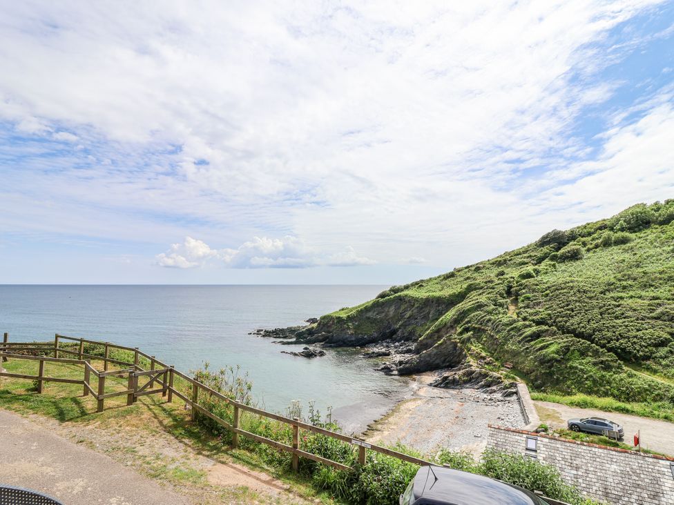 A view of the sea with surrounding grass and rocks at 2 Cliff Cottages West Portholland near Gorran Haven