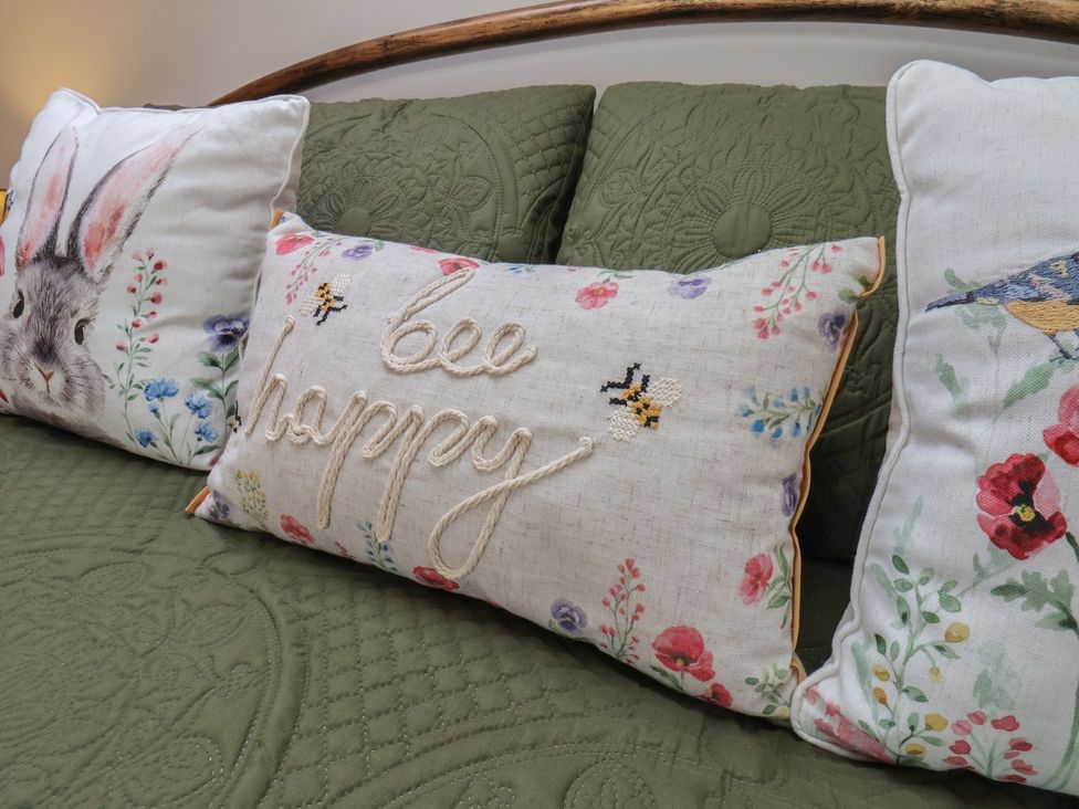 A sofa with decorative cushions at Farm Yard Cottage in Allerston