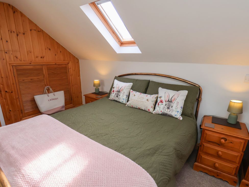 A bedroom with a bed and bedside tables at Farm Yard Cottage in Allerston
