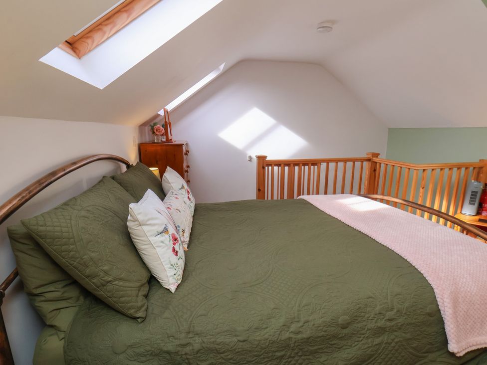 A bedroom with a bed and pillows at Farm Yard Cottage in Allerston