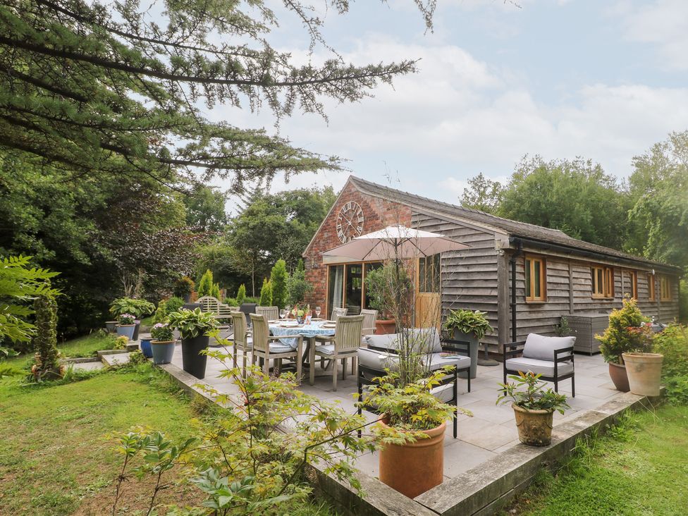 An outdoor patio area with a table and chairs at Ladycroft Barn Ashbourne