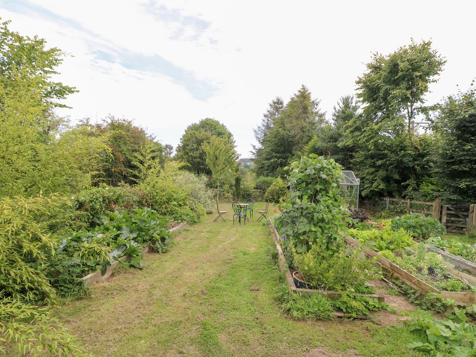 A garden with vegetable beds and a table with chairs at Ladycroft Barn Ashbourne