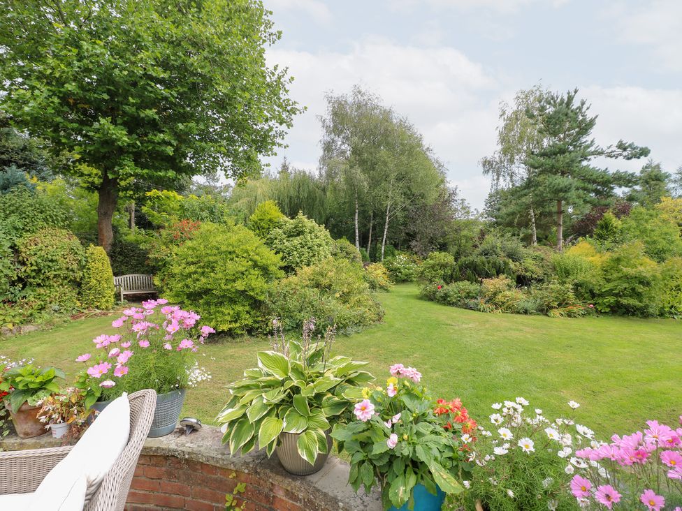 A garden with flowers and a bench at Ladycroft Barn Ashbourne