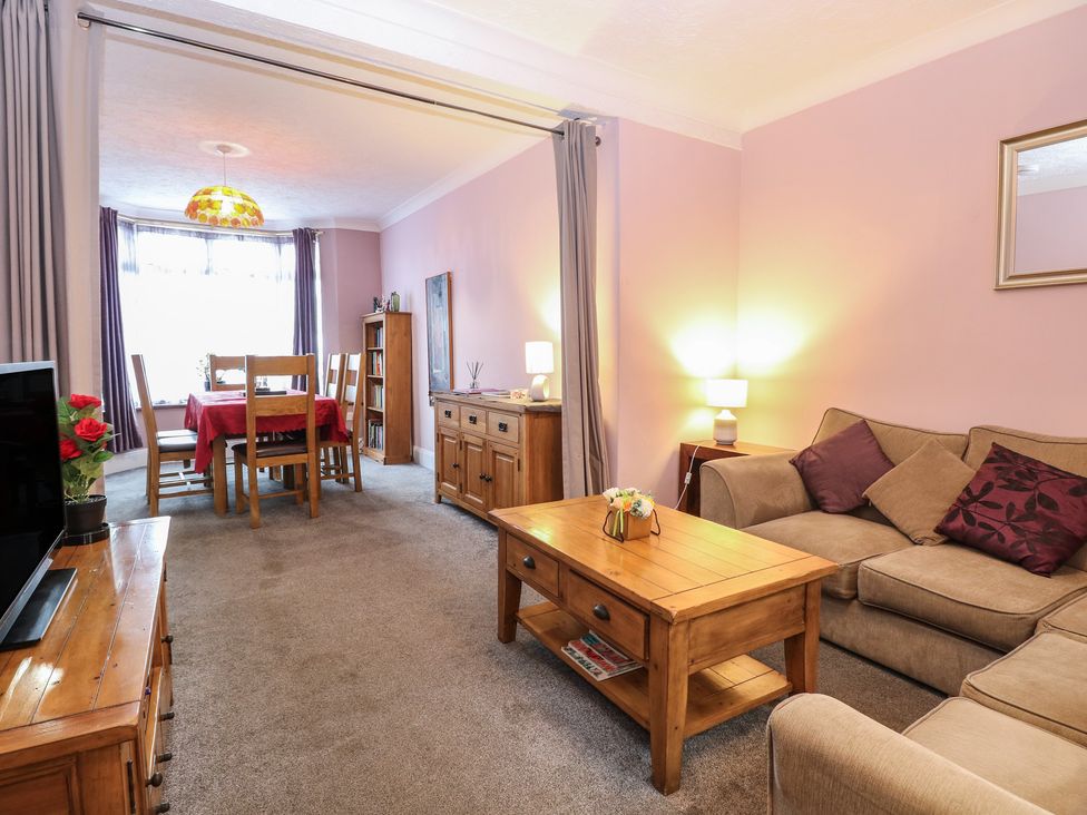 A living room with a sofa and dining area at 4 Trafalgar Square, Great Yarmouth