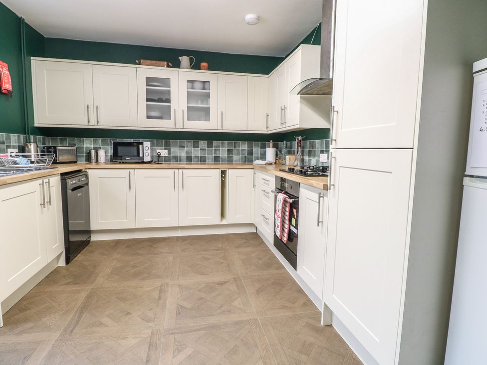 A kitchen with cabinets and appliances at 4 Trafalgar Square in Great Yarmouth