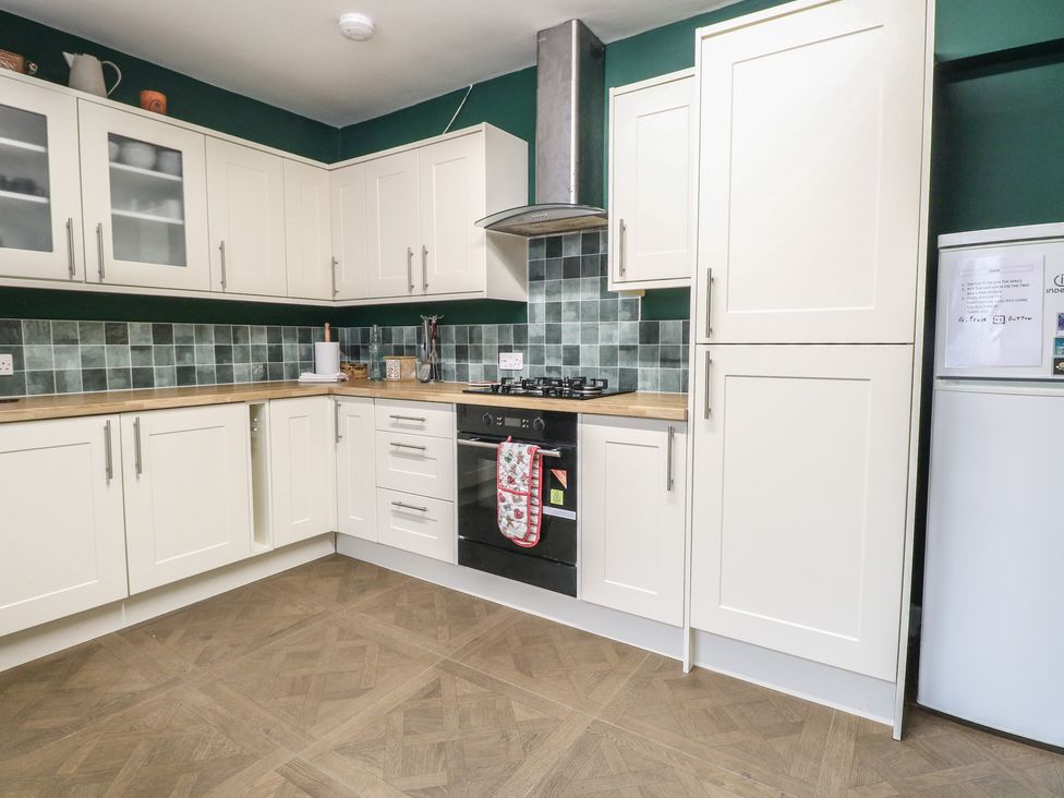 A kitchen with cabinets and appliances at 4 Trafalgar Square in Great Yarmouth