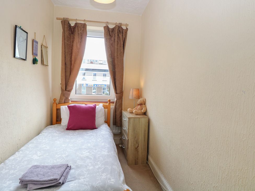 A bedroom with a bed and lamp at 4 Trafalgar Square in Great Yarmouth