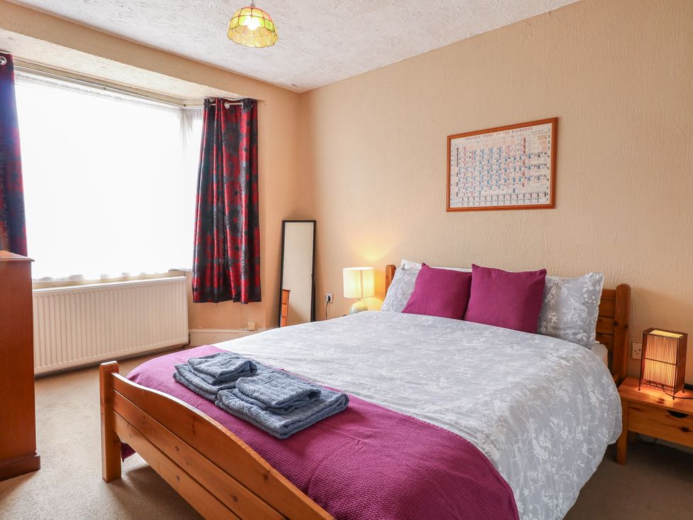 A bedroom with a bed and curtains at 4 Trafalgar Square in Great Yarmouth