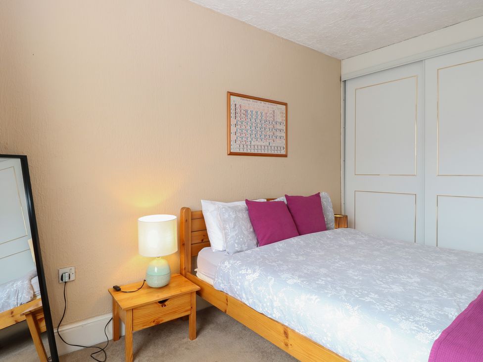 A bedroom with a bed and a lamp at 4 Trafalgar Square in Great Yarmouth