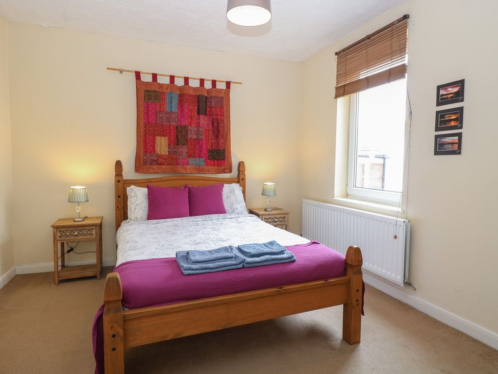 A bedroom with a bed and nightstand at 4 Trafalgar Square in Great Yarmouth