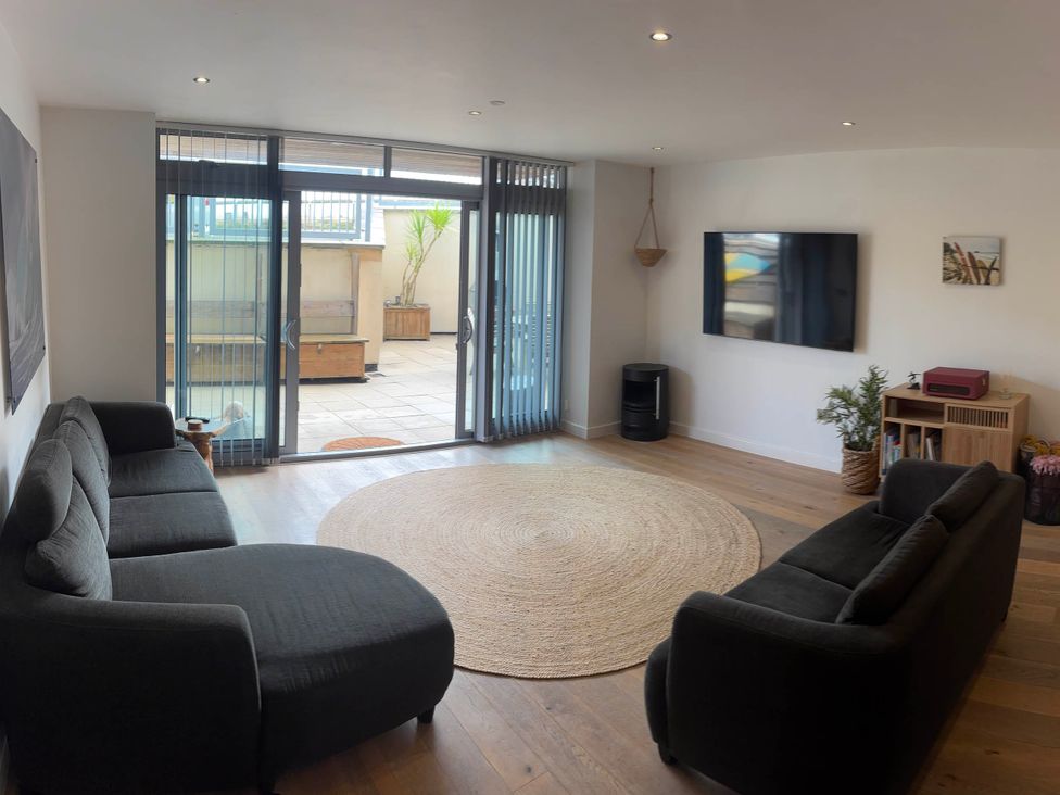 A living room with a sofa and television at Fistral Apres Surf in Newquay